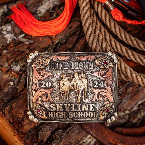 A custom rodeo betl buckle with personalized name for Skyline High School featuring a golden bronze steer wrestling cowboy figure 